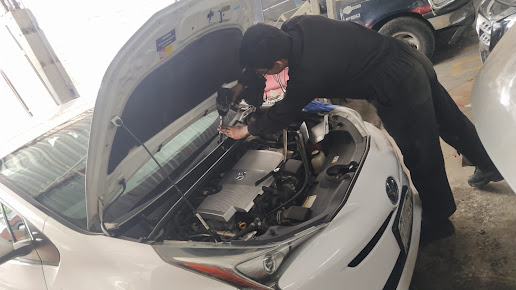 Taller automotriz con mecánicos trabajando en vehículos